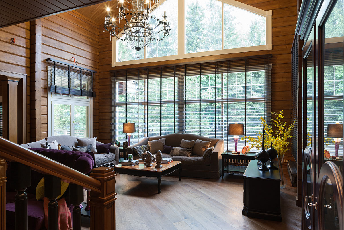 Salon z kominkiem w domu z bali, idealne połączenie relaksu i naturalnego ciepła.