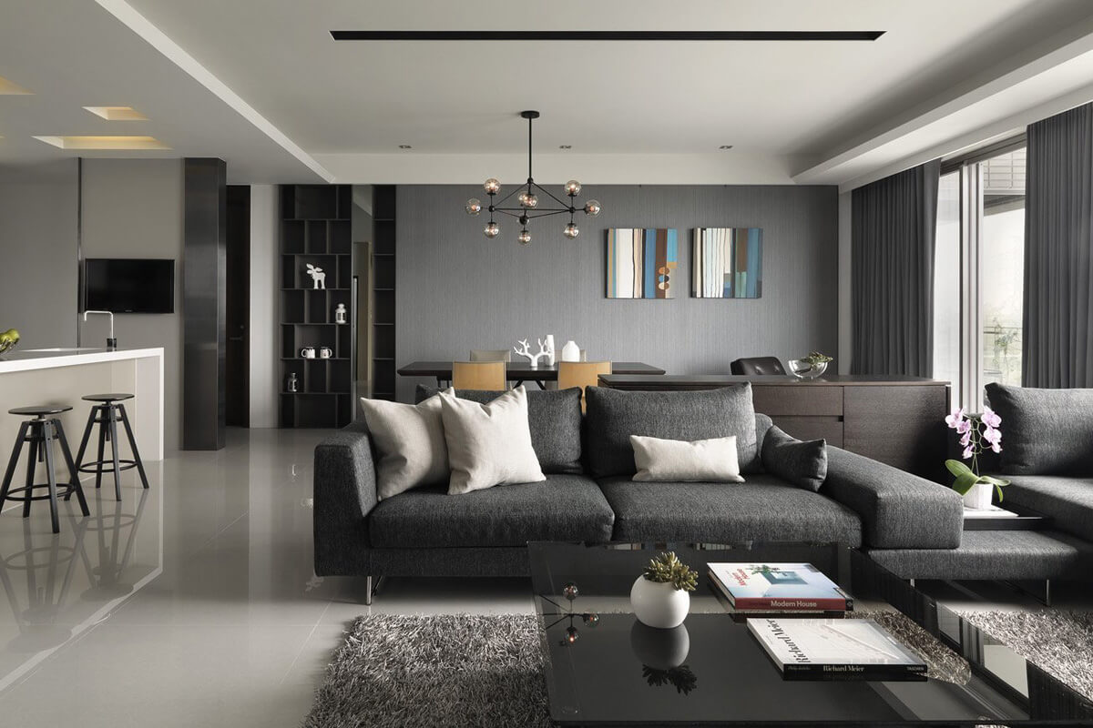 Szaro-białe wnętrze salonu w stylu skandynawskim z wygodną sofą i poduszkami.