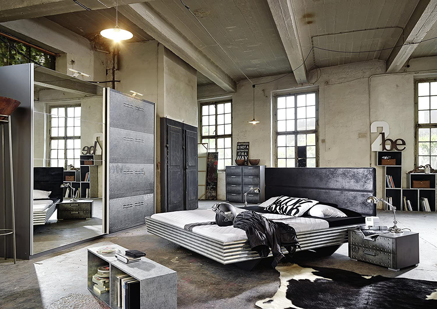 Loft: Otwarta Przestrzeń Nowoczesna sypialnia w stylu loft z otwartą przestrzenią i dużym oknem.