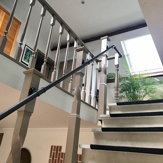 Nowoczesny stołek barowy z rurami hydraulicznymi w industrialnym wystroju.