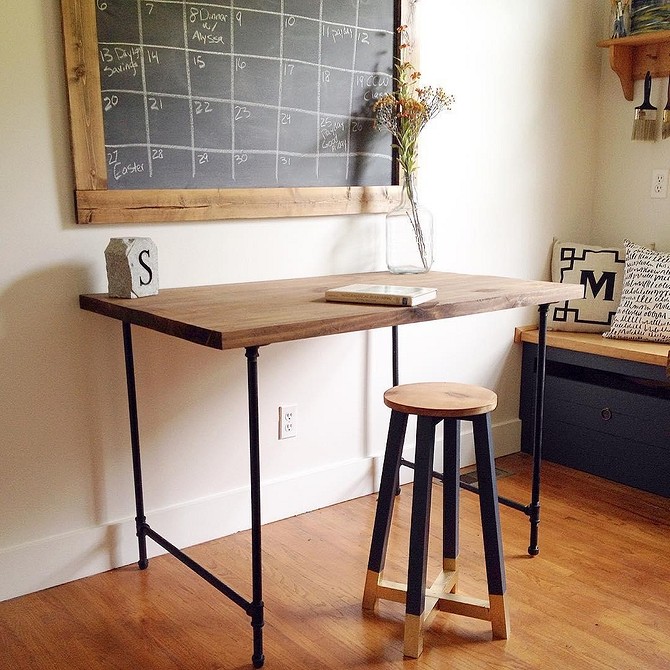 Designerski stół z metalowymi nogami z rur w loftowym wnętrzu.