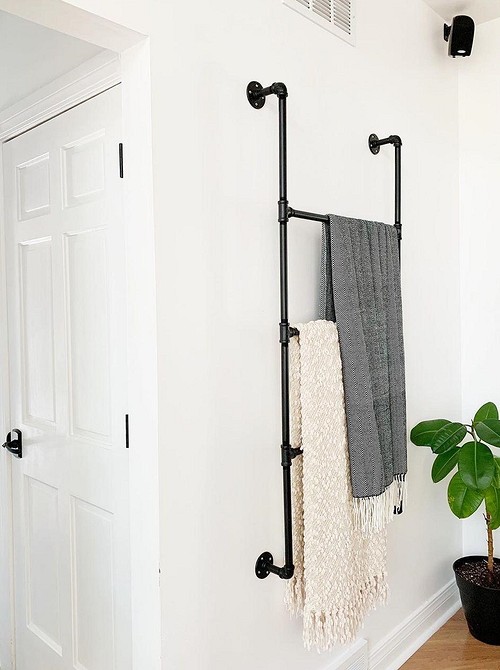 Oryginalna podstawa na kwiaty z rur hydraulicznych we wnętrzu mieszkania.