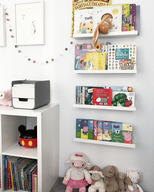 Wąska drewniana półka IKEA z książkami i roślinami w małym przedpokoju. Organizacja.