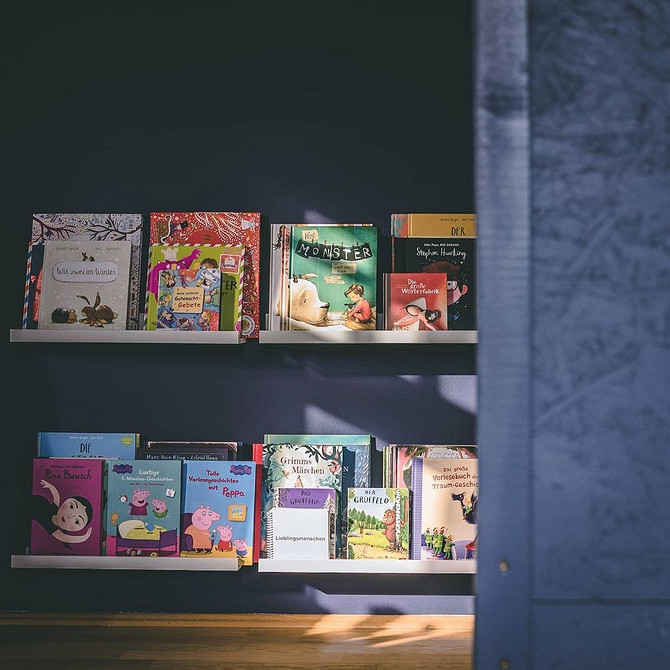 Dwie wąskie półki IKEA nad biurkiem na przybory biurowe i dekoracje. Organizacja przestrzeni.