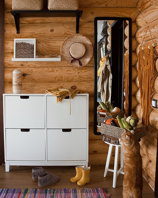 Nowoczesny przedpokój z meblami IKEA i elementami skandynawskiego designu w domu z bali.