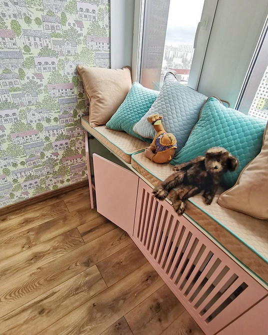 Sofa na parapecie: atmosfera Sofa na parapecie z pledem i poduszkami, ciepła i przytulna atmosfera w domu.