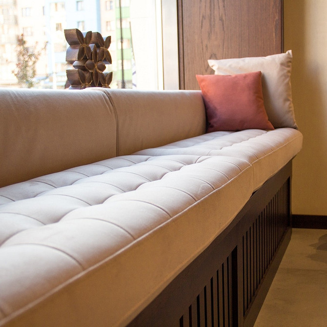 Sofa na parapecie: widok Wygodna sofa na parapecie z widokiem na miasto, nowoczesny design wnętrza pokoju.