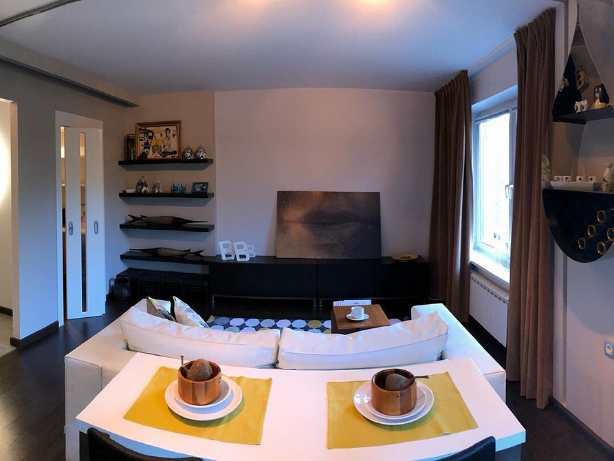 Wnętrze z białym narożnym sofaom i журнальним stolikiem w minimalistycznym stylu.