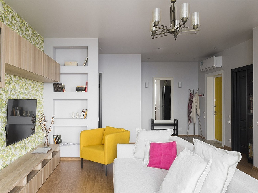 Skandynawska biała sofa. Biała sofa w stylu skandynawskim z drewnianymi nóżkami, przytulna jasna przestrzeń salonu.