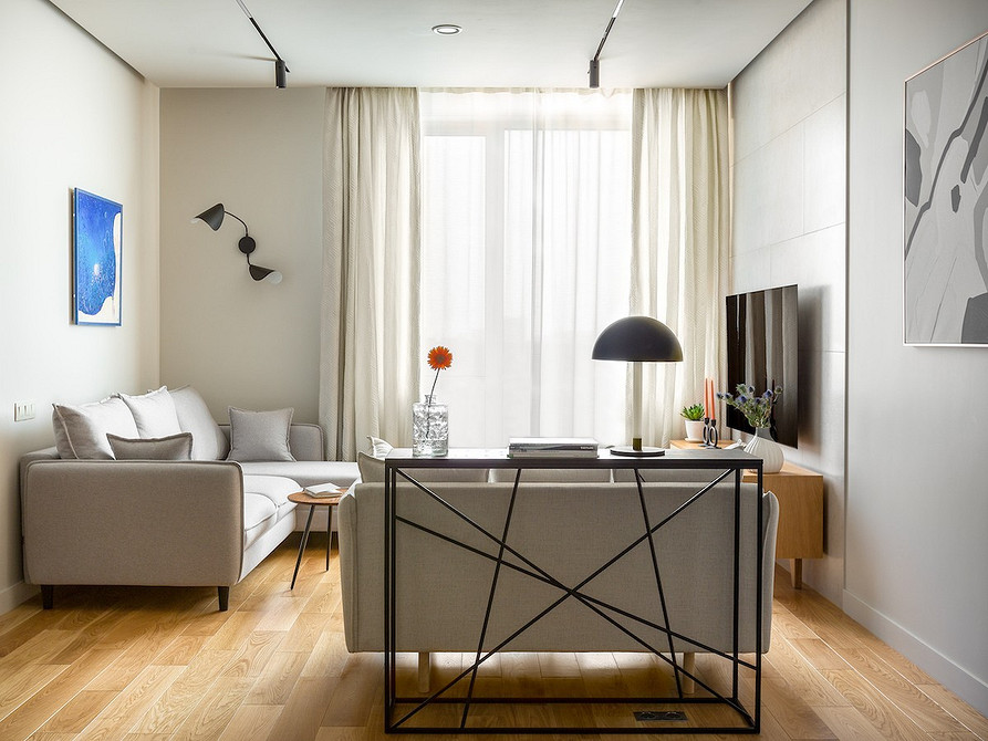 Elegancka biała sofa Nowoczesna biała sofa w przestronnym salonie, tworząca elegancką i minimalistyczną aranżację wnętrza.