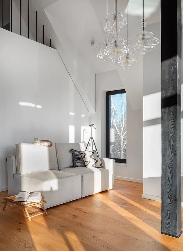 Biała sofa skandynawska Biała sofa w stylu skandynawskim z drewnianymi nóżkami w jasnym salonie.