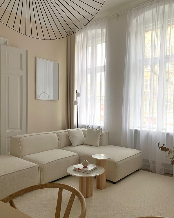 Elegancka beżowa kanapa Nowoczesna beżowa kanapa w przestronnym salonie ze stylowymi dodatkami i naturalnym oświetleniem.