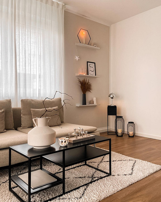 Jasny salon z beżową sofą i dekoracyjnymi poduszkami w różnych kolorach.