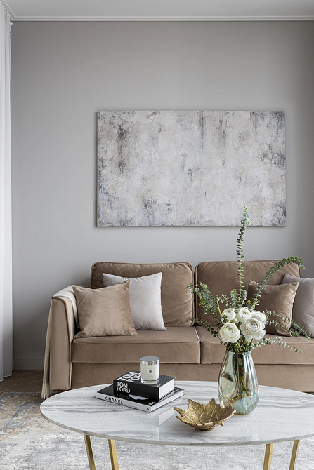 Rozkładana beżowa sofa w małym mieszkaniu, funkcjonalny design i oszczędność miejsca.