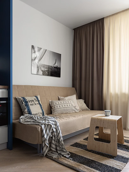 Beżowa sofa z welurową tapicerką i ozdobnymi poduszkami, elegancki design.