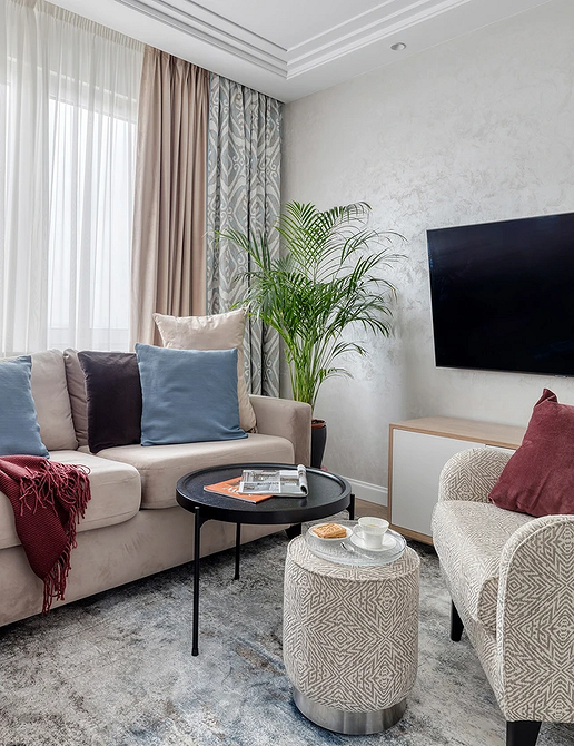 Beżowa kanapa w stylu skandynawskim Salon w stylu skandynawskim z beżową kanapą i drewnianymi elementami, podkreślający naturalność.