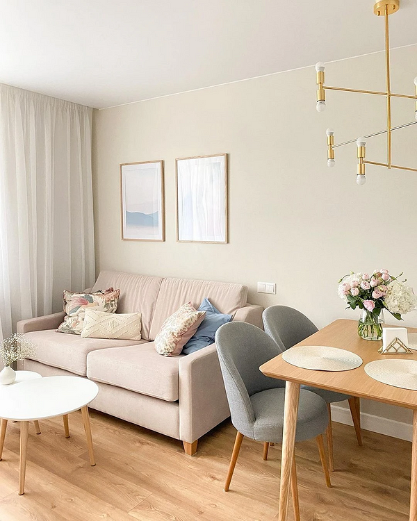 Wnętrze z beżową sofą, dywanem z geometrycznym wzorem i stolikiem kawowym.