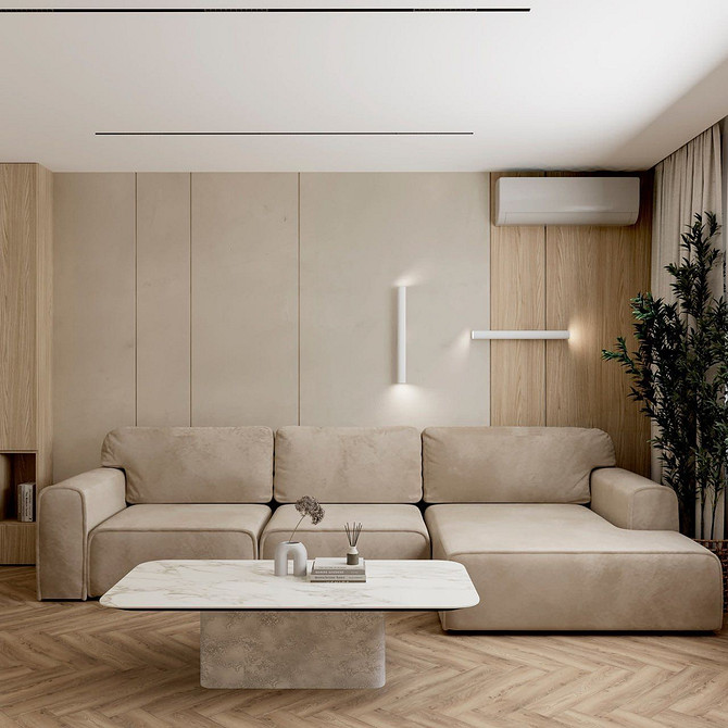 Beżowa narożna sofa w przestronnym salonie z dużymi oknami i naturalnym światłem.