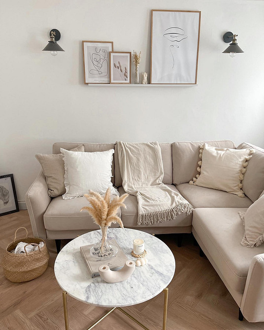 Stylowa beżowa sofa w nowoczesnym salonie z akcentującymi poduszkami i dywanem.