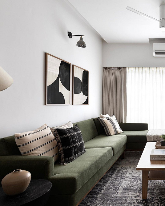 Granat i krem Eleganckie połączenie granatowej kanapy z jasnymi, kremowymi ścianami w salonie.