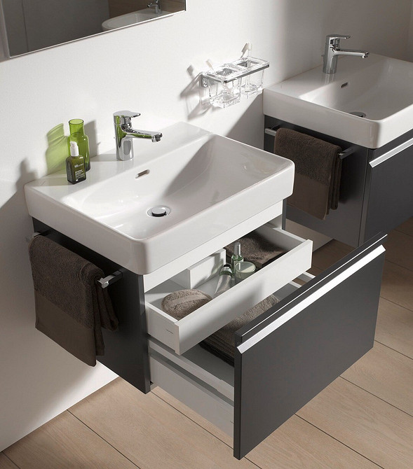 Ciemne drewno Tumbo pod umywalkę z ciemnego drewna i jasne płytki w nowoczesnej łazience.