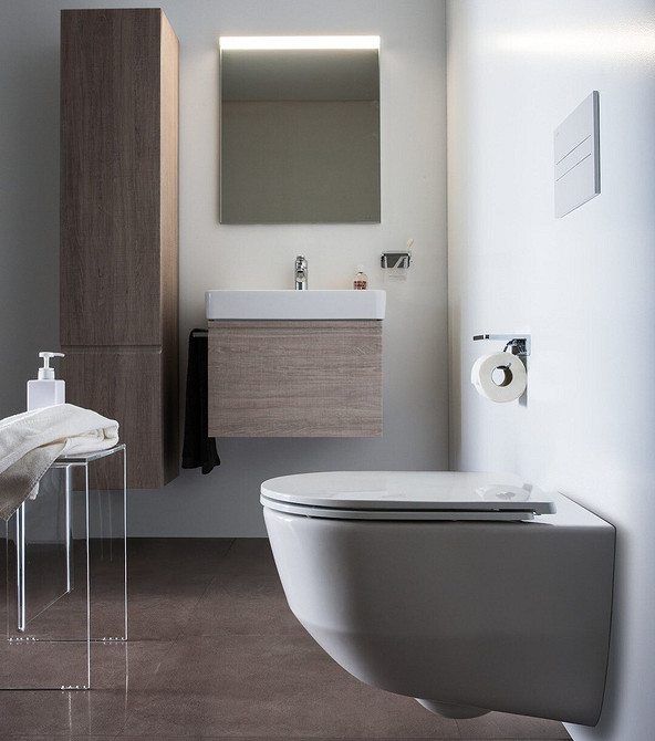 Drewno i lustro Łazienka z drewnianymi meblami i dużym lustrem optycznie powiększająca przestrzeń.