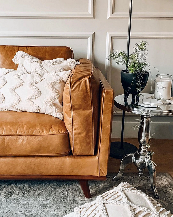 Jasna skórzana kanapa w nowoczesnym salonie. Minimalistyczny styl i elegancja.