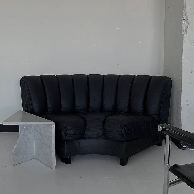 Dwa skórzane kanapy w salonie. Spójny design i dużo miejsca do siedzenia.