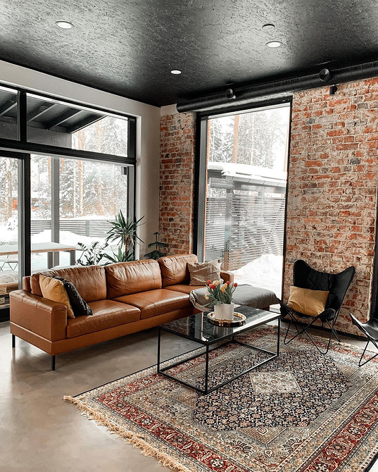 Beżowa skórzana kanapa w jasnym wnętrzu. Spokojny i przytulny design salonu.