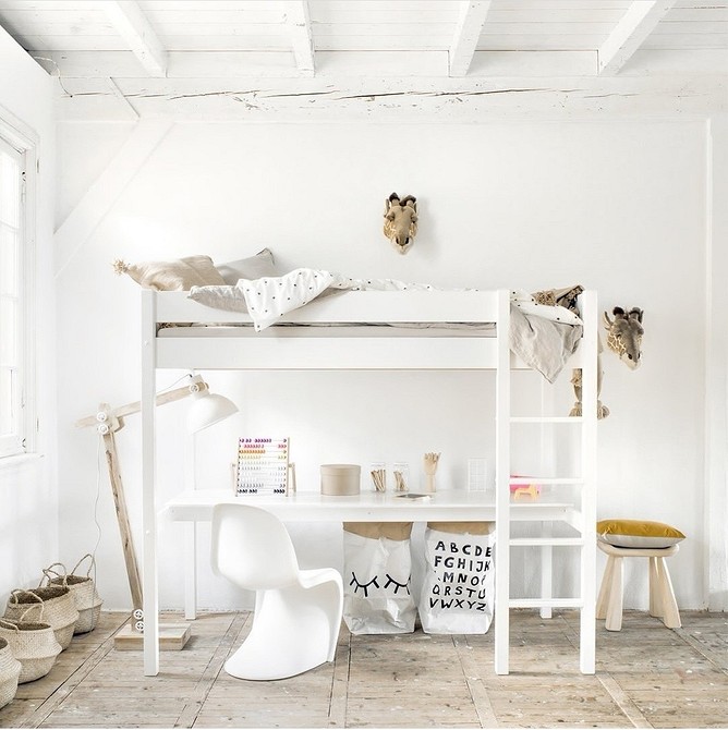 Jasne łóżko na antresoli z dużym oknem w nowoczesnym pokoju dziecka.