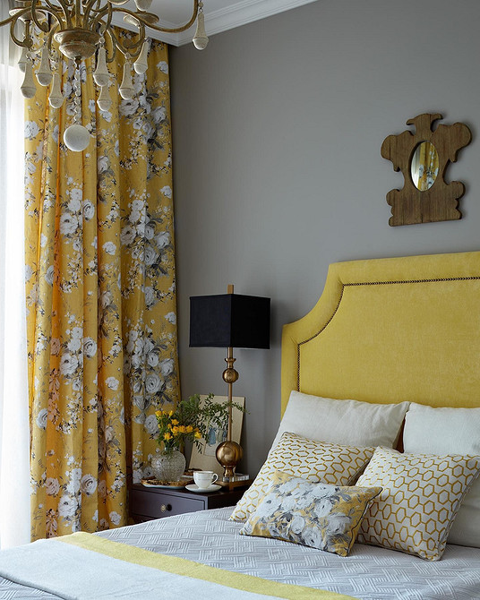 Jasna sypialnia z łóżkiem z miękkim zagłówkiem obitym jasnym materiałem