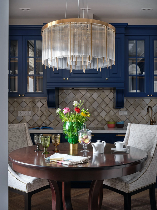 Stylowy okrągły stół z drewnianym blatem w jasnej jadalni w stylu skandynawskim.