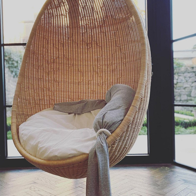 Boho relaks w salonie Stylowy fotel wiszący kokon we wnętrzu salonu w stylu boho.