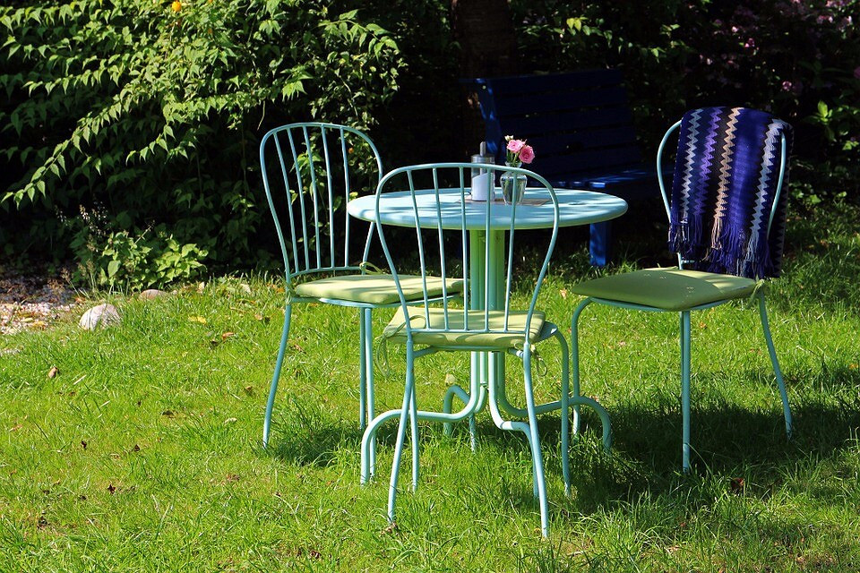 Kute piękno Eleganckie meble ogrodowe z kutego metalu: stół i krzesła z ażurowym wzorem.