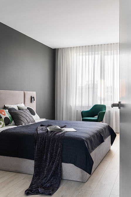 Przytulna sypialnia w szarościach z miękkim łóżkiem, drewnianymi elementami, idealna do małego mieszkania.