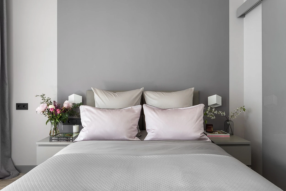 Minimalistyczne szare łóżko Nowoczesna szara sypialnia z akcentową ścianą i minimalistycznym designem.