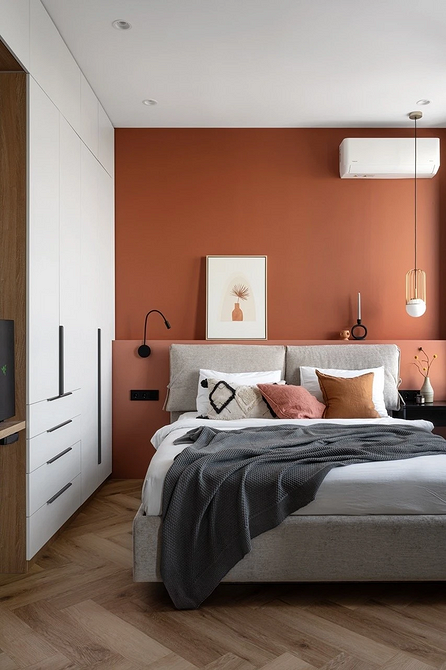 Minimalizm z poduszkami Nowoczesna sypialnia z szarym łóżkiem, minimalistycznym designem i dużą ilością poduszek.
