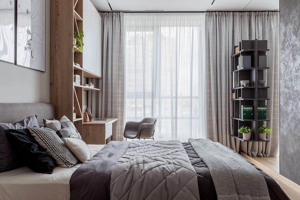 Stylowa sypialnia z szarym łóżkiem, drewnianą podłogą i nowoczesnymi lampami, minimalistyczny design.