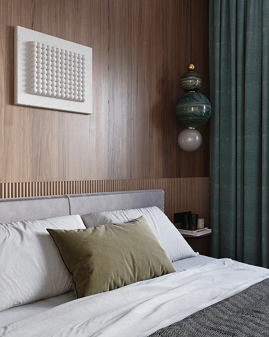 Szare łóżko w sypialni z akcentującą ścianą, tworzące przytulne wnętrze w małym mieszkaniu.