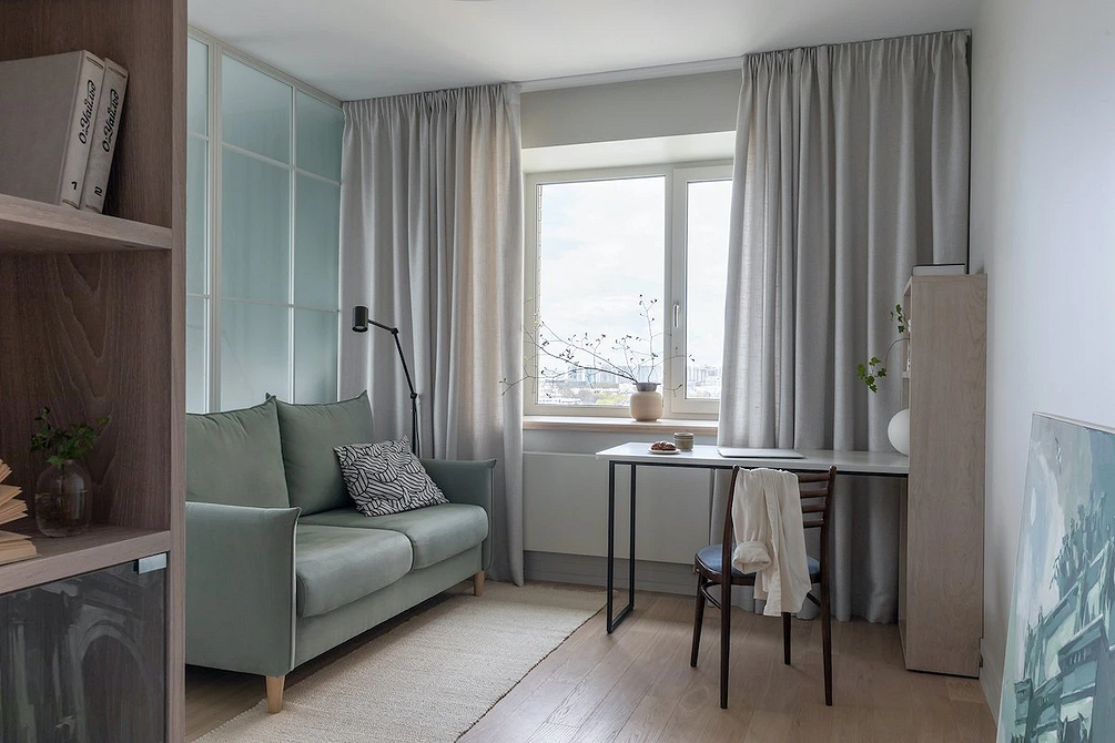 Szara sofa w strefie wypoczynkowej Neutralna szara sofa jako centralny element aranżacji strefy wypoczynkowej.