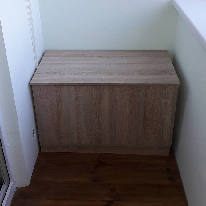 Praktyczna szafa do przechowywania przetworów i narzędzi na oszklonym balkonie.