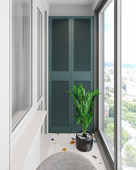 Biała szafa z drzwiczkami na balkonie: wygodne przechowywanie rzeczy.