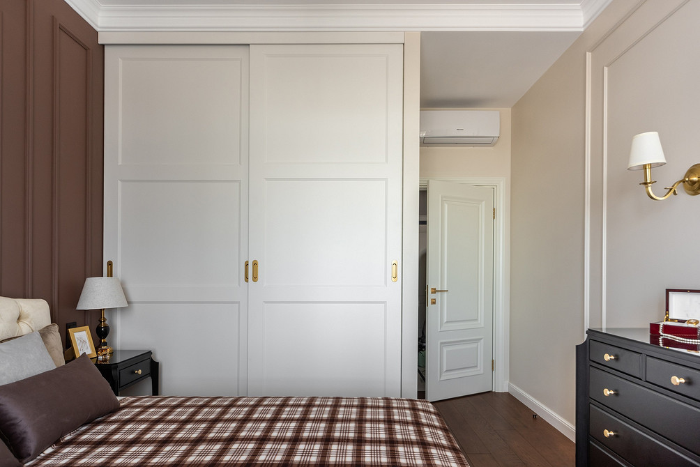 Stylowa szafa przesuwna z matowymi szklanymi drzwiami w nowoczesnej sypialni.