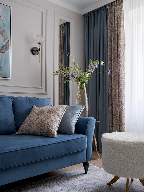 Niebieska skórzana sofa w biurowym wnętrzu z metalowymi elementami dekoracyjnymi.