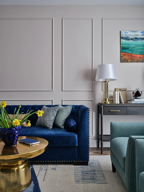 Nowoczesny, minimalistyczny salon z niebieską sofą. Idealne meble do małego mieszkania.
