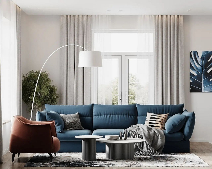 Niebieska sofa narożna w salonie z dużymi oknami. Komfortowe meble do domu.