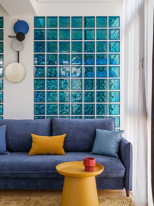 Elegancka niebieska sofa z aksamitną tapicerką w klasycznym wnętrzu pokoju.