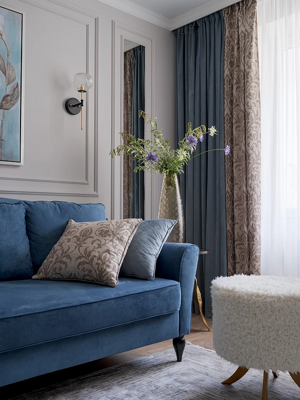 Niebieska sofa w salonie z neutralnymi kolorami ścian – aranżacja wnętrz