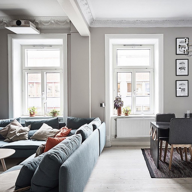 Niebieska sofa w eklektycznym wnętrzu z różnorodnymi teksturami i kolorami, tworząc unikalną przestrzeń.