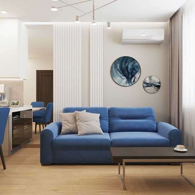 Nowoczesna aranżacja salonu z niebieską sofą i jasnymi ścianami – inspiracje 2026.